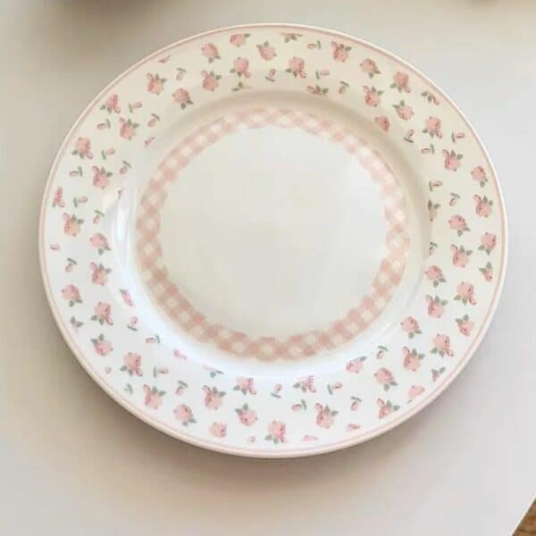 Assiette vintage plate romantique avec des motifs floraux roses posés sur une table